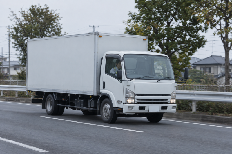 朝の幹線道路を走る4tトラック